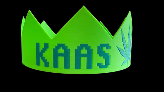 Green crown with 'KAAS' and a marijuana leaf design on a blue surface.