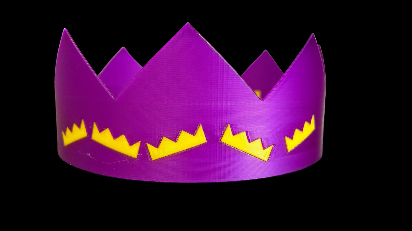 Purple crown with yellow accents on a textured surface
